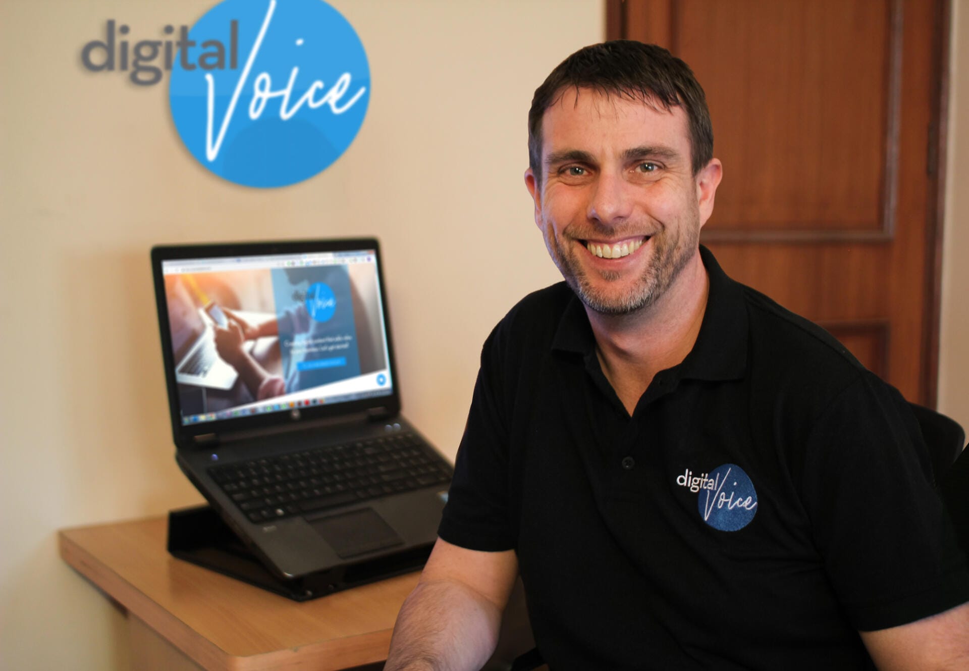Man in Digital Voice office beside laptop