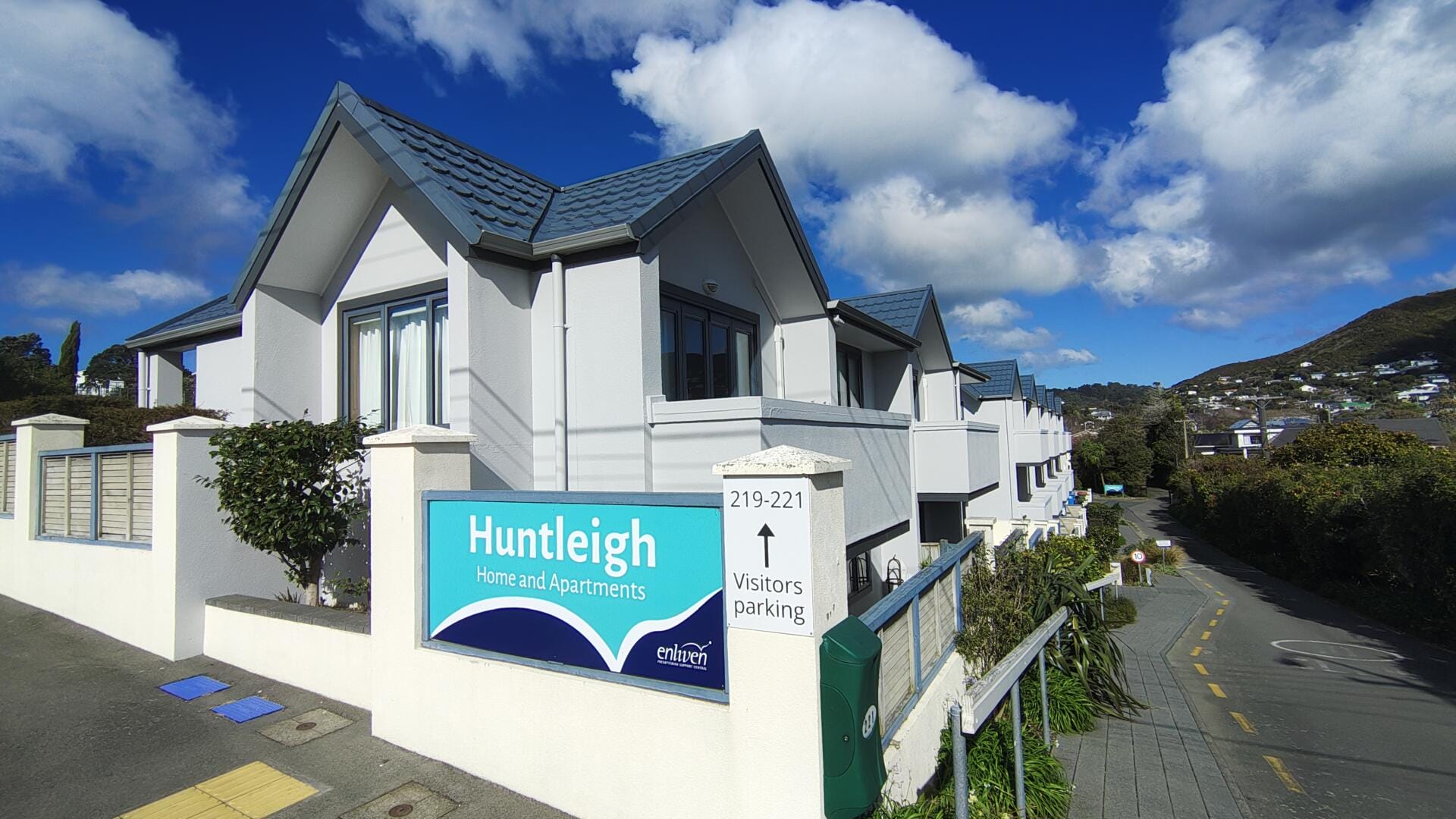 Huntleigh retirement home apartments beneath a bright cloudy sky