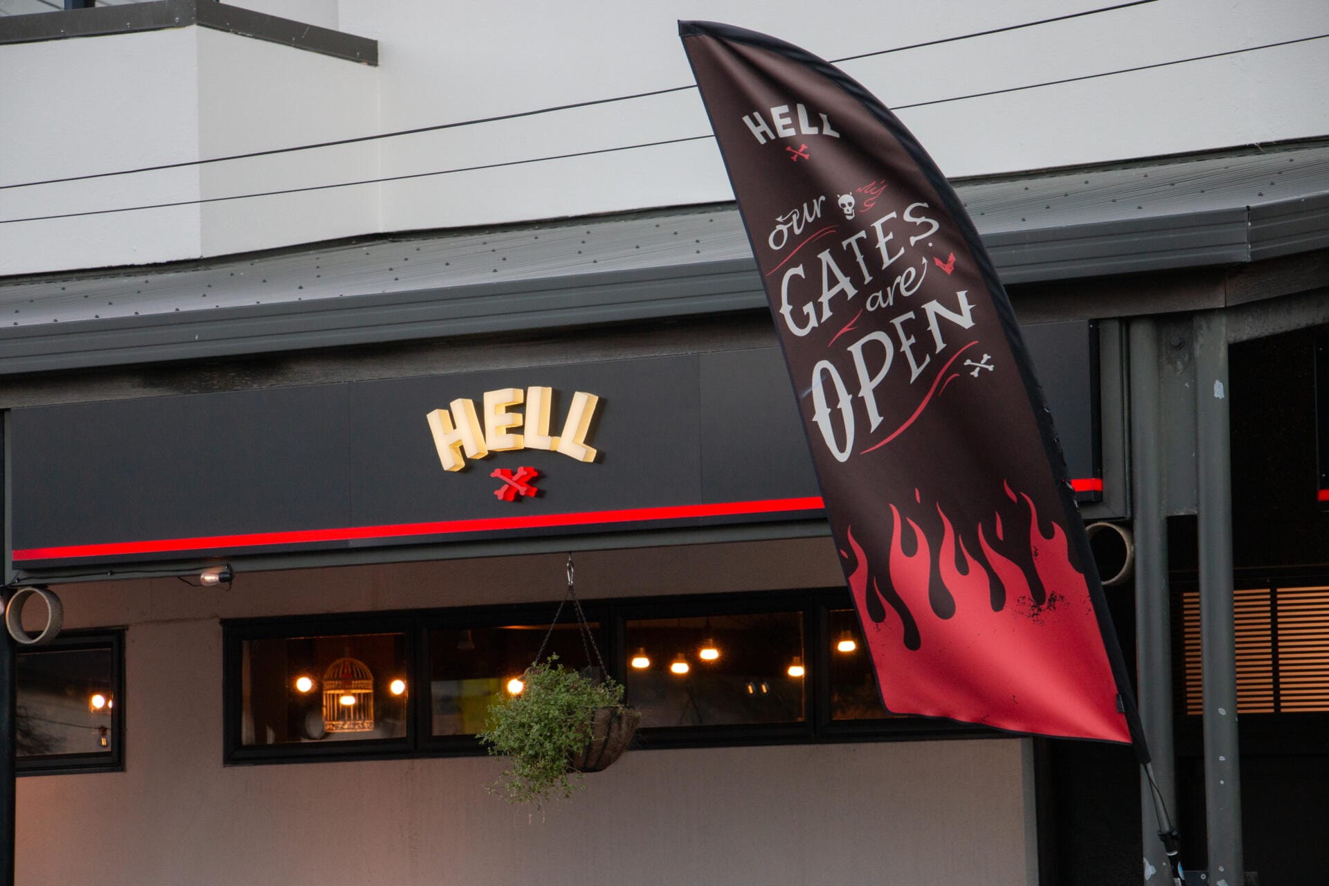 Hell Pizza storefront with open gates flag
