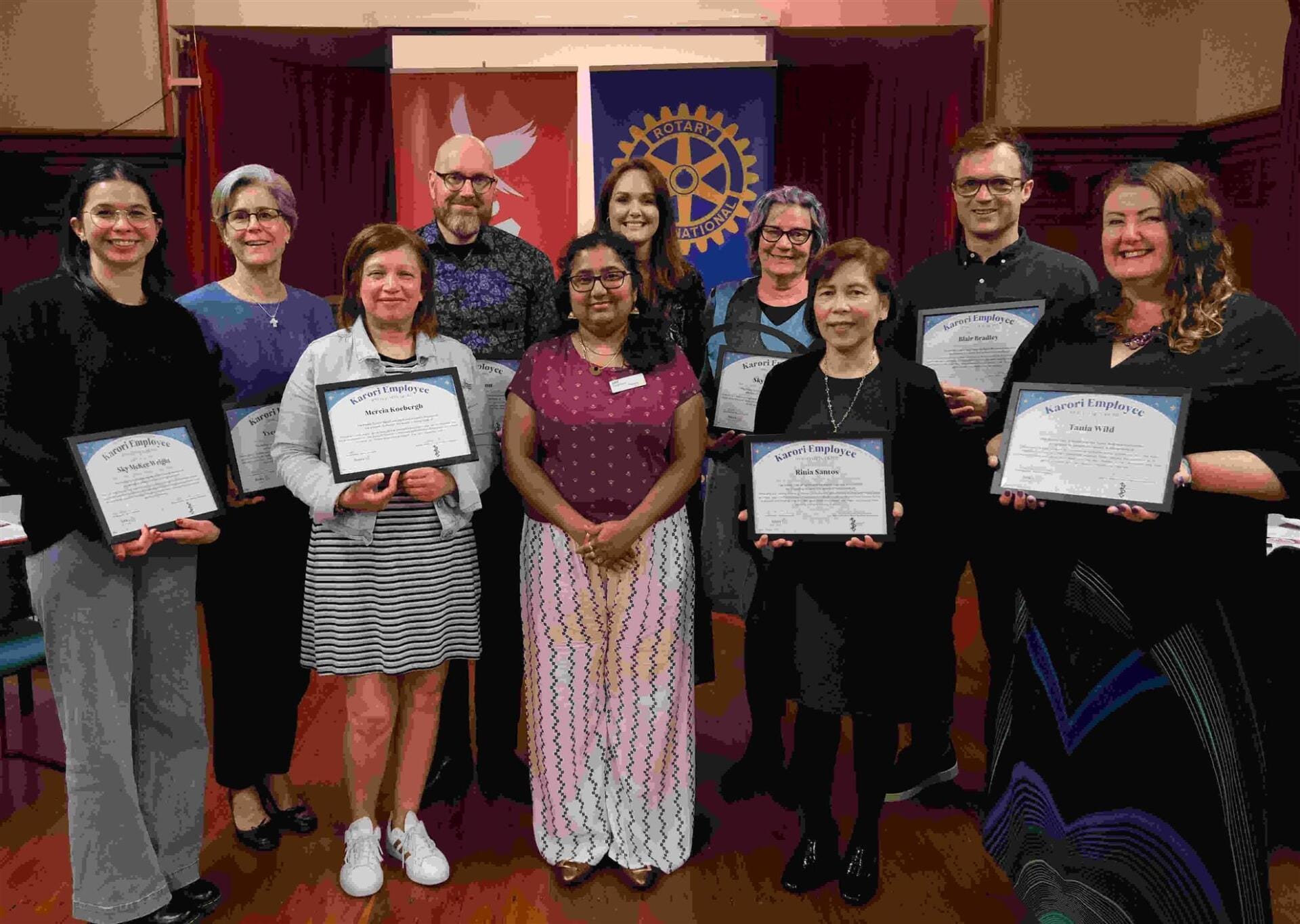 Group holding employee award certificates at ceremony