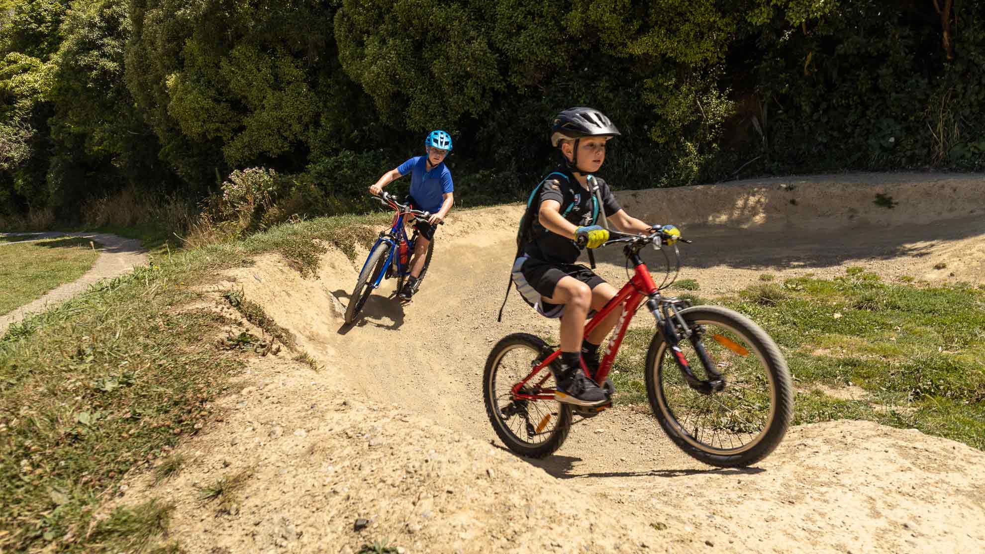 Children riding bikes on a dirt track in Karori