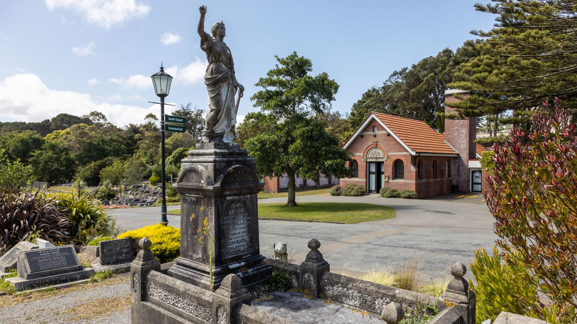 Historic cemetery statue near brick chapel building
