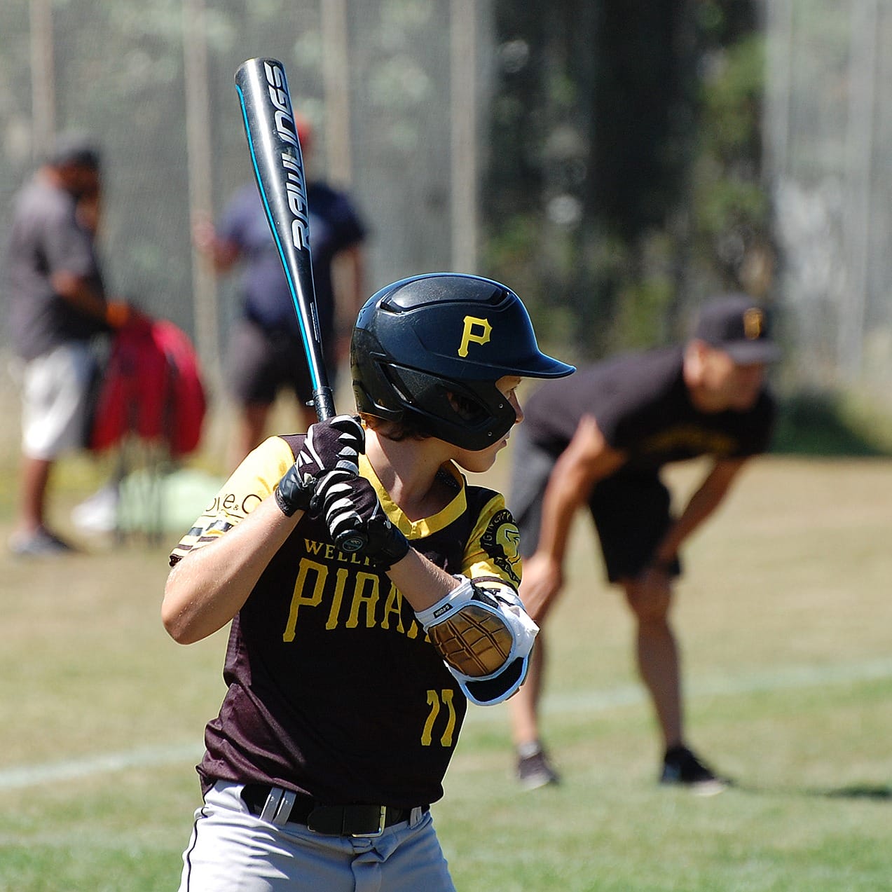 Young baseball player batting during daytime game